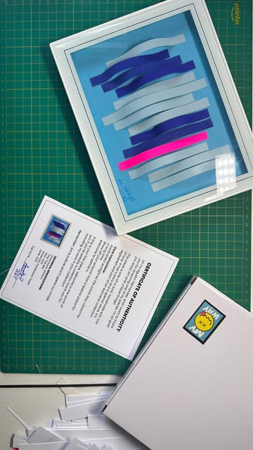 Blue Drift: layered paper strips in blues with one neon pink line, with its certificate of authenticity