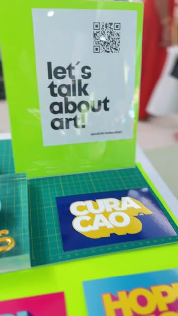 The studio's "let's talk about art!" sign at an art fair stand